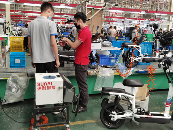 速耐技術(shù)負(fù)責(zé)人協(xié)助愛瑪員工使用自動拉釘機設(shè)備